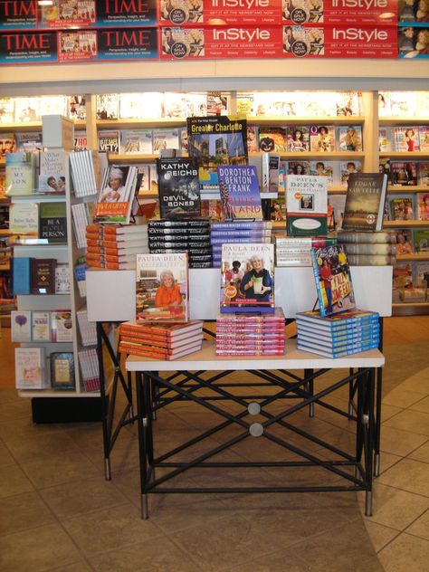 Nested tables with interesting legs help add character to the store, especially if the tables are at an entrance or in a focal point area. Bookstore Table Display, Library Styling, Bookstore Display, Nested Tables, Market Booth Display, Bookstore Design, Bookstore Ideas, Books Display, Creative Bookshelves