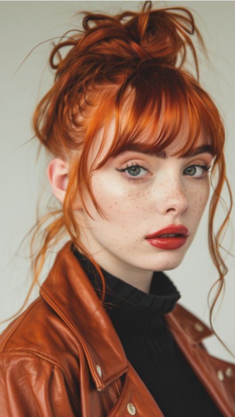 Woman with red hair and freckles wearing a brown jacket and black turtleneck.