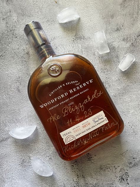 A 750ml bottle of Woodford Reserve Bourbon Whiskey with the name The Blizzards engraved on it in a calligraphy script and filled with Gold. Bourbon Wedding, Kentucky Straight Bourbon Whiskey, Holiday Promotions, Wedding Bottles, Bourbon Whiskey, Wedding Calligraphy, Private Event, Hand Engraving, Whiskey Bottle