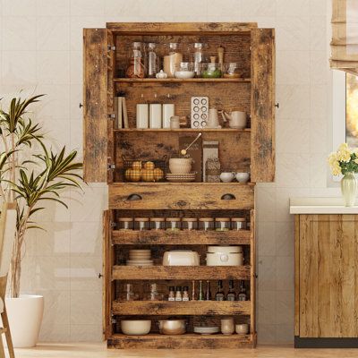 This pantry cabinet offers a versatile storage solution for your kitchen or any room in your home. Crafted from engineered wood, it features paneled drawers and black knob and cup pull handles for a classic look. With four doors, one drawer, and four shelves, this cabinet provides ample space to store food, small appliances, and kitchen supplies. The six door shelves are just right for organizing spice jars and canned goods, while the three sliding shelves offer flexible storage options. Plus, t Seasoning Storage Ideas, Unfitted Kitchen French, Herb Storage Ideas, Homesteading Pantry, Rustic Pantry Ideas, Home Apothecary Room, Hanging Kitchen Storage, Antique Pantry, Food Pantry Cabinet