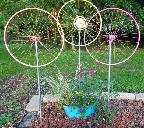 I saw my first bicycle wheel yard art a few years ago but couldn't find a how-to. My husband loves bikes so was onboard for this project and figured it out. It's actually pretty easy and inexpensive. Recently we put a bunch up on the fencing. And yes, they all spin! For this fencing version I've been considering painting a stem and leaves on the fence . Here we put a trio up against the house . .. They really do kinda look like flowers so we put the next grouping out in the yard… Whimsical Garden Art, Stepping Stones Diy, Garden Globes, Wheel Art, Bicycle Wheel, Metal Yard Art, Metal Garden Art, Bicycle Art, Garden Art Projects