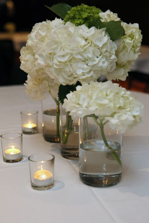 Votive Candle Centerpieces With Flowers, Hydrangeas And Candles Centerpieces, Simple White Centerpieces Flower, Hortensia Table Decoration, Tea Candle Wedding Centerpieces, Simple White Hydrangea Centerpiece, Wedding Reception Tables Centerpieces Hydrangeas, Single Hydrangea Centerpiece, Hydrangea Bud Vase Wedding