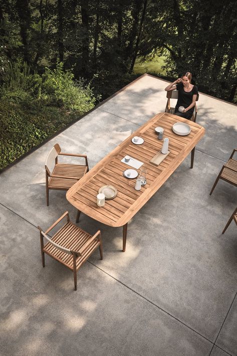 This Teak Outdoor Living Collection Pairs Sustainability and Scandinavian-Inspired Style - Photo 8 of 11 - Inspired by teak decking, and echoing the craftsmanship and design of the Tea Clippers that opened trade routes around the world, Pedersen clearly references his inspiration, using generous deck-like slats, ﬁnely tapered legs that hint at a ship’s mast—even giving the table a hull-like edge. The Clipper collection is simultaneously a nod to a nautical past, as well as a new take on al fresc Modern Outdoor Dining Sets, Modern Outdoor Dining Table, Outdoor Dining Table Setting, Modern Outdoor Dining, Teak Patio Furniture, Natural Teak Wood, Teak Outdoor Furniture, Patio Dining Table, Solid Wood Dining Chairs