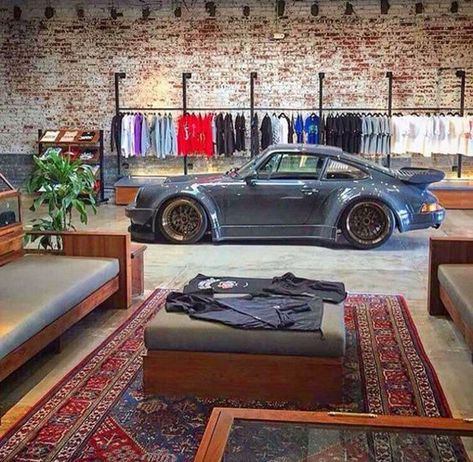 25 Coolest Automotive Living Space To Your Interior Styles | Home Design And Interior Loft Garage Industrial, Garage Couch Ideas, Garage Industrial Design, Car Shop Office Ideas, Garage With Couch, Garage Wall Mural Ideas, Industrial Garage Ideas, Mens Garage Ideas, Porsche Room Decor