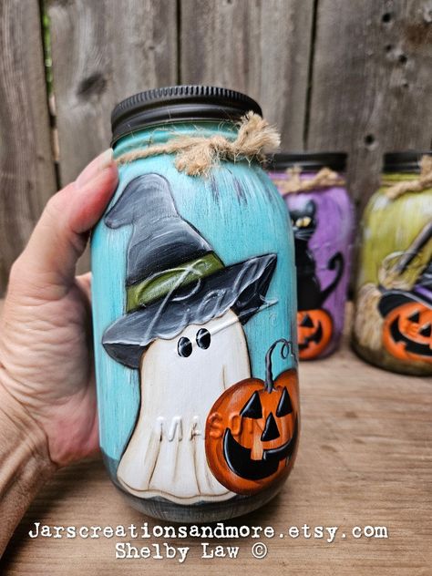 These are made to order, and sold individually. Please add which one/s you would like from the drop down bar.  They are new quart size Ball jars, that measure approximately 7 inches tall. I chalk paint the jar with two coats of chalk paint, then paint the colors and streaks with acrylic paint. I then handpaint the pattern with acrylic paint. Then seal with a clear satin sealer. I add twine around the rim.  These will be the perfect addition to your Halloween decor!  To clean,  simply wipe with a Tissue Mason Jars, Painted Glass Jars Diy, Dollar Tree Pumpkins Craft Ideas, Jar Art Paint, Mason Jar Decorating Ideas, Spooky Jars, Canning Jars Crafts, Painted Glass Jars, Mason Jar Lids Crafts