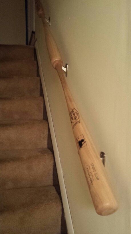 My hubby fashioned our new handrail to the basement out of baseball bats! Love it! Basement Handrail, Sports Basement Ideas, Basement Man Cave Ideas, Baseball Basement, Sports Room Man Cave, Stair Idea, Rec Room Basement, Sports Cave, Sports Man Cave