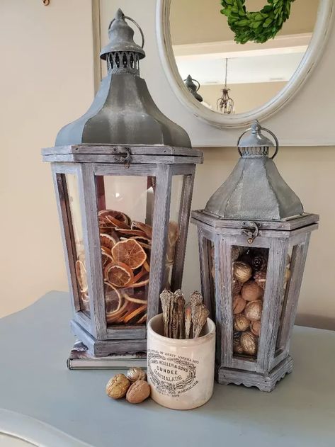 Welcome to Cloches & Lavender where I share crafts, DIY's and Home décor ideas.This is a particularly great time to speak about how to add filler décor to lanterns seasonally. Because the seasons are going to be changing, this is the time we begin thinking about adding warmer touches to our homes.The cooler temperatures that will be here soon makes a fun time to add some of my all time favorite pieces as filler décor for lanterns.How I Updated My Lanterns To Lighten ThemSo, now, le… How To Decorate A Lantern, Lantern Filler Ideas, Rustic Farmhouse Mantle, Lantern Jar, Entryway Boho, Centerpiece Coffee Table, Bird Cage Ideas, Candle Holders Wall, Halloween Cozy