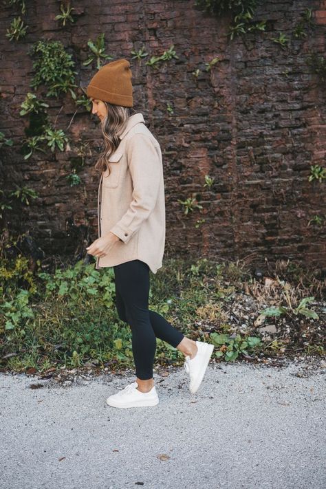 ashley wearing a tan shacket, black leggings, white sneakers, and brown beanie standing in front of a rock wall with green plants Fall Outfits Tennessee, Fall Airforce 1 Outfit, Cream Fleece Shacket Outfit, Outfit With Brown Beanie, Brown Leggings Outfit Work, Shacket Outfit With Leggings, Blush Pink Shirt Outfit, Comfy Shacket Outfits, Shacket And Sneakers Outfit