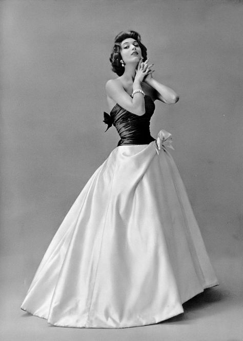 1956 Marie-Hélène in beautiful evening gown of a full white satin skirt topped by a gray draped top that ties in a bow in the back, by Pierre Balmain 1950s Gowns Evening Dresses, 1950s Gown, White Satin Skirt, 1959 Fashion, Drawing Tut, 50s Glamour, Balmain Fashion, Beautiful Evening Gowns, Betty Dress