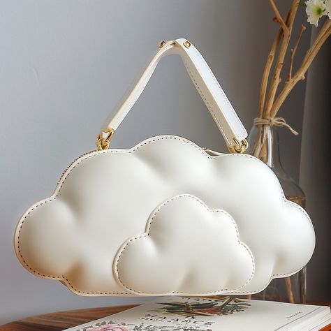 The cloud-shaped handbag is a whimsical accessory that adds a touch of dreaminess to any outfit. Crafted from soft, high-quality materials, this handbag mimics the fluffy, ethereal look of a cloud. Its gentle curves and smooth texture create an inviting, playful silhouette. The bag features a spacious interior with secure compartments, making it both stylish and practical. With its charming design and impeccable craftsmanship, the cloud-shaped handbag is perfect for those who love to make a f... 3d Elements, Whimsical Accessories, Cloud Bag, Cloud Shapes, Smooth Texture, Bag Making, Fashion Statement, Texture, Sewing