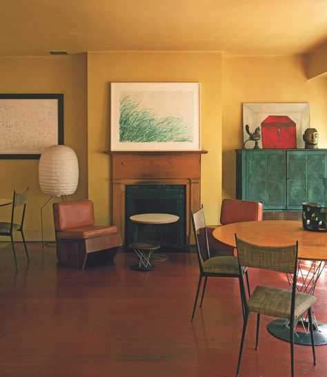 Italian-born painter Francesco Clemente favors bold earthy hues throughout, a palette inspired by the pigments in his own work. “He liked the idea of living among his frescoes”  In his dining room, mustard walls harmonize with a Twombly print, a Basquiat drawing (left) and one of the artist’s own paintings (right). Stronger colors, too, can act as surprisingly effective backgrounds for hanging art. “Petrol blue or chartreuse or acid yellow—those are really big color schemes at the moment.” Mustard Blue Living Room, Yellow Ochre Living Room, Living Room With Yellow Chairs, Ochre Dining Room, Ochre Living Room Colour Palettes, Yellow Ceiling Bedroom, Bold Interior Paint Colors, Paint Color Schemes For Home Interior, Yellow Wall Living Room Ideas