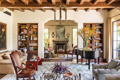 In the living room, built-in bookcases are paneled with decorative wallpaper and feature custom-made air-return grilles whose design is based on traditional Spanish Revival styles. Spanish Colonial Style Homes Interior, Spanish Colonial Interior Design, Colonial House Interior, Spanish Colonial Homes, Spanish Revival Home, Colonial Interior, Colonial Style Homes, Mediterranean Home Decor, Spanish Style Home