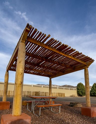 This spacious RV patio site at the Albuquerque KOA Journey features a custom shade pergola with a unique Southwest flavor. Southwest Landscaping, Shade Pergola, Black Pergola, Rv Patio, Desert Backyard, Covered Terrace, Santa Fe Home, Desert Style, Fire House