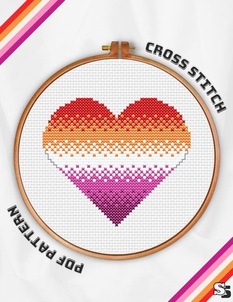 A wooden embroidery hoop containing a cross stitch of a large heart in the colours of the lesbian pride flag. Heart Cross Stitch Pattern, Flag Cross Stitch, Lgbtq Pride Flag, Heart Cross Stitch, Pride Heart, Needlepoint Ornaments, Lesbian Flag, Trans Pride, Cross Stitch Heart