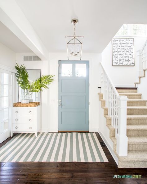 Beach House Front Door Coastal, Coastal Foyer Lighting Entryway, Modern Coastal Foyer Lighting, Modern Coastal Foyer Entryway, Light Blue Doors Interior, Light Blue Front Door White House, Coastal House Entryway, Coastal Modern Wallpaper, Coastal Blue Front Door