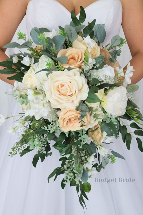 This lovely assortment of ivory, sand, and white is bound to turn heads on your wedding day. Composed of stunning roses alongside white peonies and greenery, this cascading brides’ bouquet from the Frankie collection is an absolutely breathtaking arrangement for any bride to be. This bouquet is 10” wide, 18” long, and is crafted by hand by our in-house florists. If you love the style of this bouquet but you have chosen a different accent color, keep in mind that color changes are free of charge. Fake Flower Bride Bouquet, August Wedding Flowers Bride Bouquets, Bridal Bouquet White With Greenery, Small Bridesmaid Bouquets, Peach Bouquet, Bridal Party Bouquets, Peach Wedding Flowers, Cascading Bridal Bouquets, Cascading Wedding Bouquets