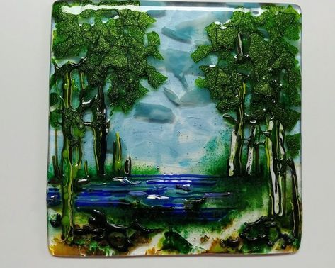 This fused glass landscape art depicts a tree and water scene.   I just love making fused glass trees.  The clear stands shown in some of the photos come with the art.   If you scroll through the photos you will see that this glass landscape changes somewhat, depending on the dominant source of light.  At times the sky is all blue, at times there is a hint of lavender there.  Displaying this piece on a shelf or windowsill instead of flat against a wall allows light to enter from behind. Some of Birch Trees Landscaping, Glass Landscape, Clay Painting, Seaside Landscape, Glass Trees, Polymer Clay Painting, Fused Glass Panel, Water Landscape, Glass Fusion Ideas