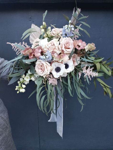 a beautiful bridal bouquet with quicksand roses, white anenomies and blue delphinium Bouquet With Delphinium, Rose And Delphinium Bouquet, Wedding Bouquet Delphinium, Delphinium Bridal Bouquet, Blue Thistle Bouquet, Moab Rose, Bridal Bouquet With Blue Thistle, Thistle Bouquet, Blue Thistle