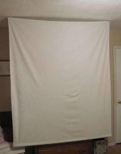 If you regularly tear the wrinkled sheets off your bed to use them as a makeshift projector screen, it's time to upgrade. Make this portable screen on the cheap that stashes away in a closet til the next time you need it. Retractable Projector Screen, Backyard Movie Screen, Diy Projection Screen, Diy Movie Screen, Projector Screen Diy, Diy Outdoor Movie Screen, Backyard Movie Theaters, Screened Porch Decorating, Old Screen Doors