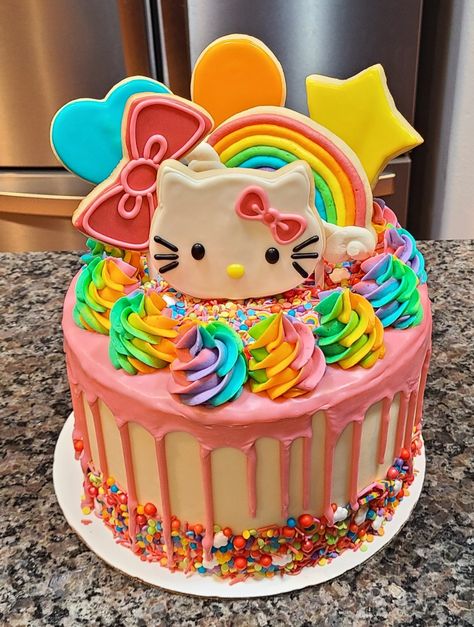 Buttercream, white chocolate drip, decorated sugar cookies, sprinkles, rainbow hello kitty theme birthday Hello Kitty Drip Cake, Hello Kitty Birthday Cake Buttercream, Rainbow Kitty Cake, Hello Kitty And Friends Birthday Cake, Hello Kitty 6th Birthday, Kitty Cakes Birthdays, Super Kitties Birthday Cake, Hello Kitty Cakes Birthday, Hello Kitty Birthday Cake Ideas