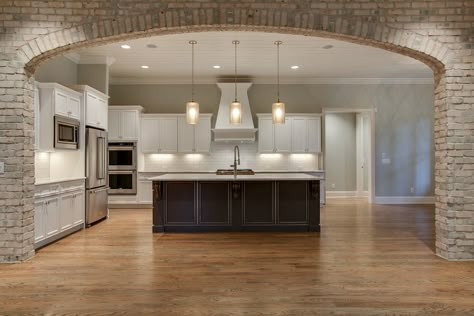 Kitchen perfectly framed by interior brick arch. Brick Opening To Kitchen, Pillars In Kitchen, Arched Kitchen Opening, Brick Arch Kitchen, Archway Into Kitchen, Kitchen With Arch Opening, Brick Arches Interior, Stone Archway Interior, Interior Brick Archway