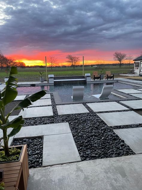 Pavers With River Rock, Pavers With Black Rocks In Between, Dark River Rock Landscaping, Rock Around Pool, Pavers With Rocks In Between, Black Rock Landscaping, Pervious Pavers, Landscape Design Backyard, Rock Scaping