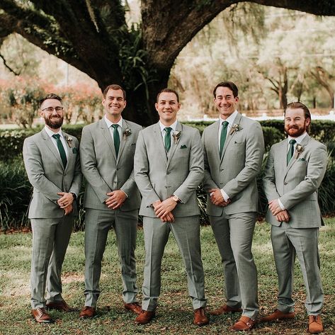 Groomsmen Fashion Inspiration 💚 Venue: @mossestatesvenue⁠ Photography: @monicagracephotography⁠ ⁠ For more Central Florida wedding inspiration follow @WhiteRabbitEventPlanning⁠ ⁠ #whiterabbiteventplanning⁠ #orlandoweddingvenues #barnweddingvenue #weddingphotographer #loveisinthedetails #groomfashioninspiration #groomsmenfashion #boutonniere #dayweddings Grey Green Suit Men, Light Grey Suit Green Tie Wedding, Grey Green Tuxedo Wedding, Sage Green Tuxedo Wedding Groomsmen, Gray Suits For Men Wedding Green Tie, Grey And Green Suit Men, Sage Green Country Wedding Groomsmen, Sage Green And Grey Groomsmen, Groomsmen With Green Ties