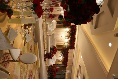 Beautiful wedding decorations with red roses and elegant chandeliers perfect for your Walima or Nikka! Follow us for more ideas and inspiration for your big day! #wedding #weddingdecoration #redroses #romantic #luxurious Red And White Wedding Venues, Red Rose Stage Decoration, Red Reception Decorations, Pakistani Baraat Decor, Wedding Red Theme Decor, Asian Wedding Dress Red, Pakistani Wedding Decoration Barat, Red Wedding Stage Decor, Barat Decoration Pakistani