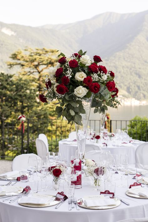 Tall Transparent vases topped with red and white roses, gypsophila and a touch of greenery Wedding Decoration Red And White, Trumpet Centerpiece Wedding, Red Sage And White Wedding, Elegant Red Wedding Theme, Red White And Rose Gold Wedding, White And Red Wedding Centerpieces, Red Roses And Greenery Centerpiece, Elegant Wedding Red Roses, Red Green Wedding Decor