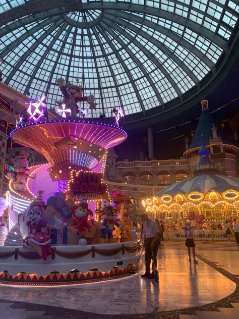 Lit up carousel taken on low exposure with a lotte world statue and a giant dome overheard. Summer nights, amusement parks and unforgettable memories. Lotte World Aesthetic, Lotte World Seoul Aesthetic, Lotte World Seoul, Korean Vacation, World At Night, Korea Photography, Seoul Night, Goals 2024, South Korea Photography