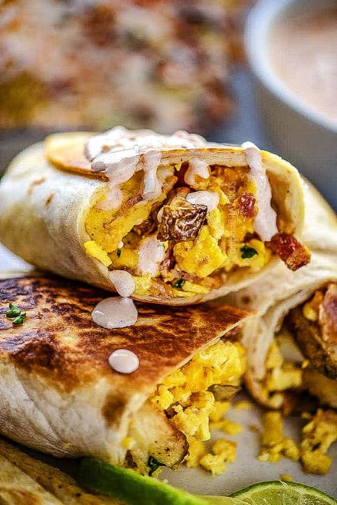 up close of a breakfast burrito drizzled with sauce Best Burittos Recipes, Breakfast Burrito Dipping Sauce, Grilled Breakfast Burritos, Sauce For Breakfast Burritos, Blackstone Breakfast Burritos, Breakfast Burrito Sauce Recipe, Breakfast Burrito Sauce, Burrito Sauce Recipe, Blackstone Breakfast