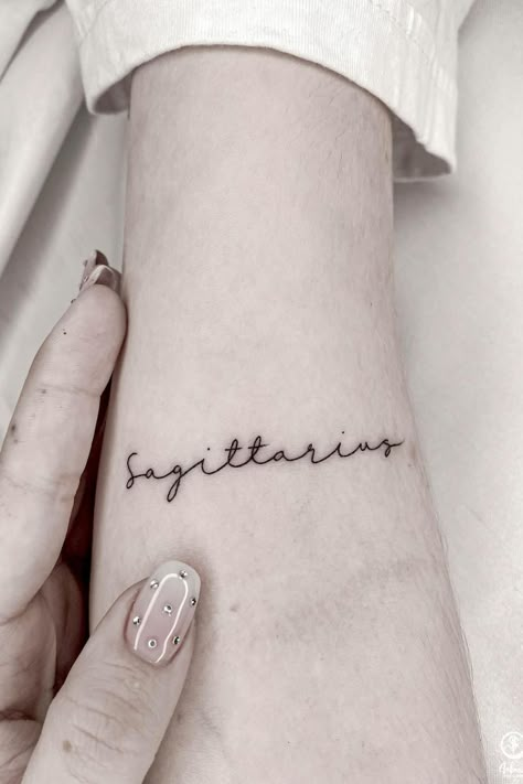 Sagittarius Writing Tattoo, Small Sagittarius Tattoo Simple, Red Sagittarius Tattoo, Sagittarius Word Tattoo, Saggitarius Tattoo For Women, Sagittarius Inspired Tattoos, Simple Sagittarius Tattoo Designs, Small Saggitarius Tattoos, Sagittarius Tattoo Aesthetic