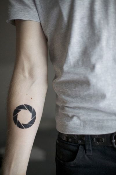 Video games have been extremely popular for years now. It is only fitting that gamer tattoos for men have become a popular choice. There are some things to consider when deciding on a video game… Aperture Tattoo, Circle Tattoo Design, Video Game Tattoos, Lower Arm Tattoos, Gamer Tattoos, Circle Tattoo, Camera Tattoo, Muster Tattoos, Gaming Tattoo