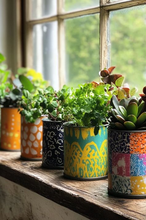 A stylish image of upcycled tin can planters showing off colorful plants, presenting creative DIY gardening ideas with a focus on eco-friendly living. Upcycled Hanging Planter, Coffee Can Planters Flower Pots, Painted Tin Cans Planters, Coffee Can Flower Pots, Tin Can Pots Planters, Potted Plant Decorations, Paint Can Repurpose, Tin Can Art Diy Ideas, Tin Diy Ideas