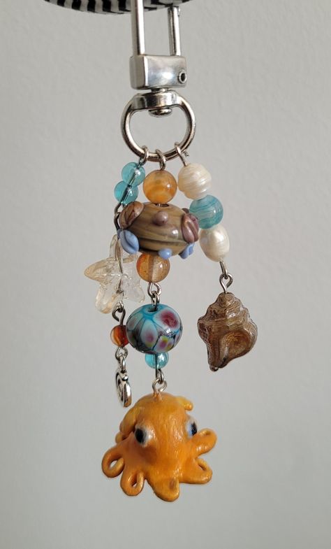 This handmde keychain features a polymer clay octopus charm. lampwork beads, glass beads, and freshwater pearls! Available on my shop ! Polymer Clay Keychains, Polymer Clay Octopus, Clay Octopus, Keychain Polymer Clay, Octopus Keychain, Clay Keychain, Creative Accessories, Beaded Necklace Designs, Polymer Clay Charms