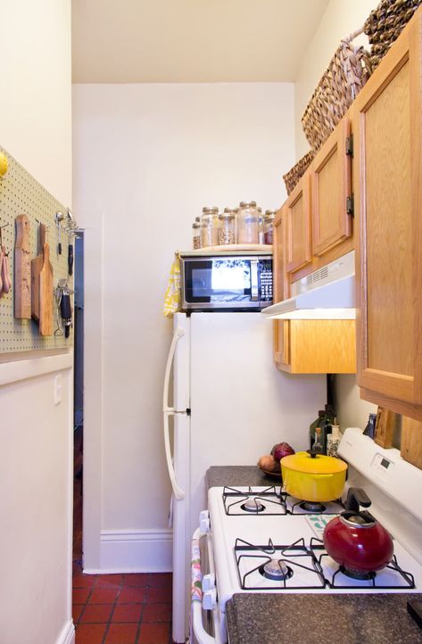 The Lazy Susan above the microwave is cool, too. Keith just added one small support to the wall and a piece of wood rests on the wall support and the microwave. (Image credit: <a href="https://www.apartmenttherapy.com/authors/adrienne">Adrienne Breaux</a>) Kitchen Half Wall, Half Wall Kitchen, New Orleans Apartment, Apartment Therapy House Tours, Bathroom Gallery Wall, One Wall Kitchen, Vintage Apartment, Space Saving Kitchen, Rental Apartment