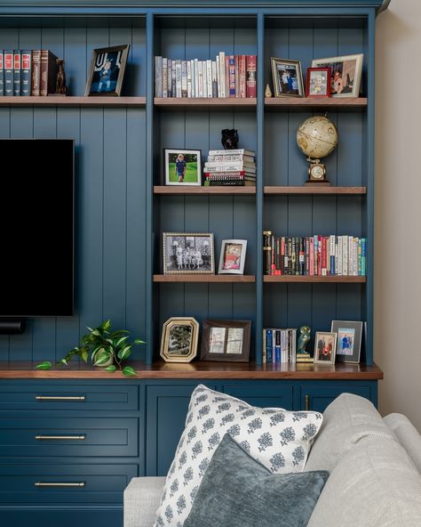 Styling shelves is about showcasing the things that make your home you. 🌿📚 Thoughtfully arranged personal items bring character and charm to this entertainment center, creating a space that feels both polished and personal. Design: @colorandcrownid 📸: @meghanbalcomphotography Builder: @jrmaxwellbuilders Cabinetry: @minkrunmillwork Blue Bookshelf, Blue And Wood, Green Bookshelves, Blue Bookshelves, Dark Wood Shelves, Blue Bookcase, Styling Shelves, Built In Bookcase, Built In Shelves