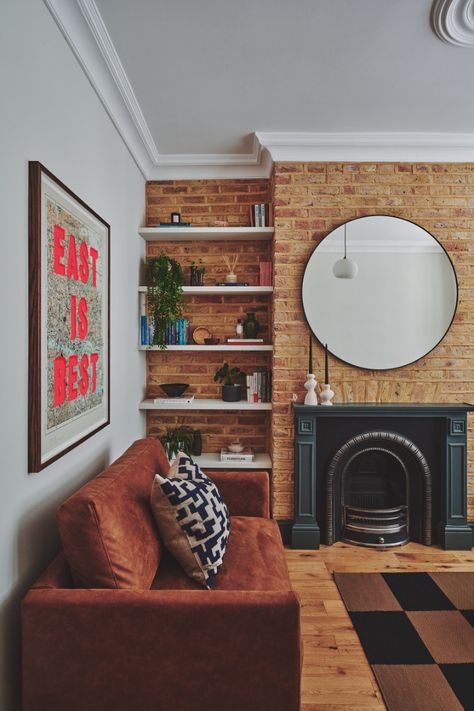 Victorian modern living room with exposed brick wall and checkerboard rug. Exposed brick wall and retro design for a young professional home. Brick Sofa Living Room, Interior Brick Wall Ideas Living Room, Exposed Brick Color Palette, Brickwall Interiors Living Room, Exposed Brick Fireplace Living Room, Red Brick Wall Living Room, Victorian Modern Living Room, Exposed Brick Walls Living Room, Living Room With Exposed Brick