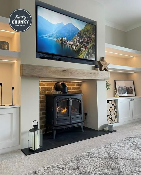 This image shows a neutral-toned living room that has white walls and alcove shelving. On the main wall, there is one of our oak mantels which has added the perfect finishing touch to the room. Tv Above Log Burner, Log Burner Tv Wall, Chunky Furniture, Cedar Beams, Alcove Ideas Living Room, Alcove Ideas, Neutral Colour Scheme, Wood Burning Stoves Living Room, Log Burner Living Room