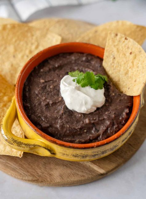 This creamy black bean dip is easy to make with just 3 ingredients. Serve it with tortillas chips, on tostadas, or molletes. It's a versatile snack or side dish that goes well with any Mexican dish. Recipe on ThaiCaliente.com Mexican Restaurant Bean Dip, Black Bean Dip Easy, Black Bean Sides, Mexican Black Bean Dip Recipe, Black Bean Refried Beans, Bean Dip Recipes Refried, Mexican Bean Dip, Instant Pot Beans Recipe, Tortillas Chips