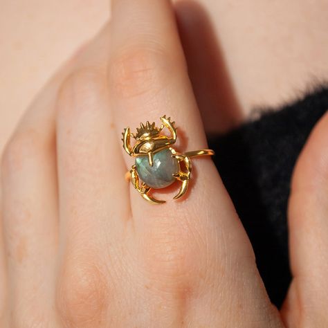 This beautiful ring is made in Sterling Silver and coated with a thick layer of 24K Yellow Gold to a Gold Vermeil thickness and set with a natural Labradorite. 24K Gold Vermeil jewelry is not only hypoallergenic, but it also does not tarnish.  Your ring is meticulously handcrafted and hand-polished to perfection. It is made to last a lifetime with proper care. This is a unique piece of minimalist jewelry for everyday wear.  Please note: Due to the one-of-a-kind nature of the gemstone, exact colors and patterns may vary slightly from the image shown. PLEASE REVIEW THESE INSTRUCTIONS TO LEARN ABOUT HOW TO PROPERLY CARE FOR YOUR JEWELRY.  To properly store your jewelry, store your jewelry in the jewelry bag, and place the jewelry bag in your jewelry box. Doing so will protect and improve the Crystal Rings Gold, Moon Face Ring, Metal Rings Handmade, Nature Accessories, Layering Rings, Scarab Ring, Yellow Gemstone Ring, Gold And Silver Ring, Handmade Silver Jewellery