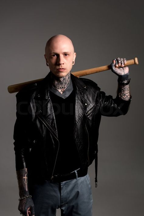 Cool tattooed man in leather jacket holding baseball bat on shoulders and looking at camera isolated on grey, stock photo | Stock Images Page | Everypixel Guy Holding Bat Reference, Holding Bat Over Shoulder Pose, Holding A Bat Pose Reference, Holding Bat Behind Head Pose, Male Pose Reference Holding Something, Holding Baseball Bat Reference Drawing, Holding A Pokeball Reference, Holding A Baseball Bat Reference, Baseball Bat Over Shoulder Pose