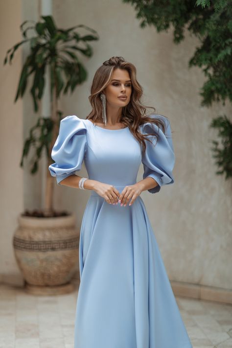 Embrace the magic of sky-blue with our Sky-Blue Backless Puff-Sleeve Midi Dress. The mesmerizing color evokes a sense of tranquility and beauty, while the backless design adds a daring and sultry touch. #mididress #skybluedress #bluedress #dress #dresses #womenwear #stylish #chic #backless #elegant #dressup #dresslover #weddingdress #eveningdress Woman Dress Midi, Blue Bridesmaid Dresses Sleeves, Puff Sleeve Dress Formal, Elegant Modest Dresses, Blue Classy Dress, Sky Blue Dresses, Blue Dress Aesthetic, Blue Dress Elegant, Dress Simple Elegant