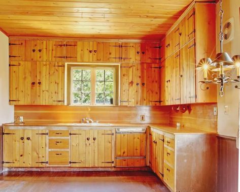 An old kitchen interior with wooden floors, knotty pine kitchen cabinets and ceiling Pine Cabinet Doors, Knotty Pine Kitchen Ideas, Update Pine Kitchen Cabinets, Tongue And Groove Kitchen Cabinets, Natural Pine Kitchen Cabinets, Countertops With Pine Cabinets, Pine Walls Kitchen, Knotty Pine Cabinets Makeover, Wood Ceilings Kitchen