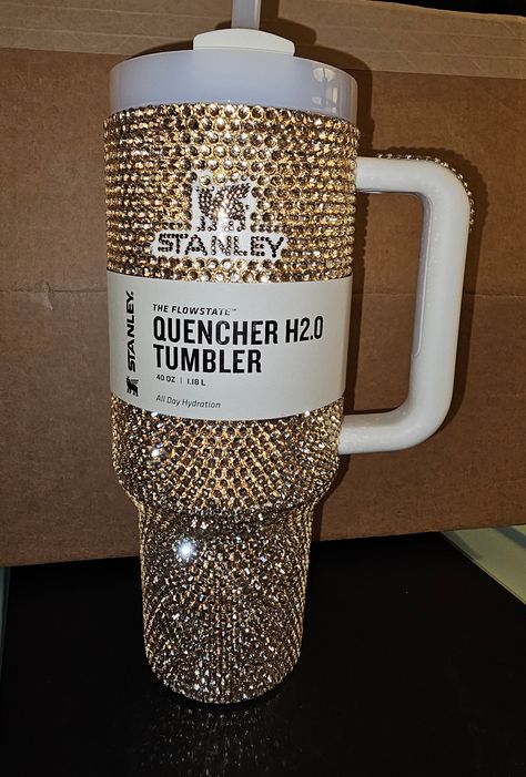 Beautiful Bling Golden 30oz Stanley Rhinestoned with Brown Logo / Covered the silver top rim with gold rhinestones along with the rubber piece on the handle / I can make this into my Crystal Stanley with the same beadwork on the handle and silver rim if you don't like gold / can take me up to 5 weeks to make and mail (depends on how many orders I have at the time) Rhinestone Stanley Cup, Cute Stanley’s, Bedazzled Stanley, Bedazzled Things, Bedazzled Liquor Bottles, Bedazzled Bottle, Gem Tattoo, Rhinestone Cups, Diy Wine Glasses