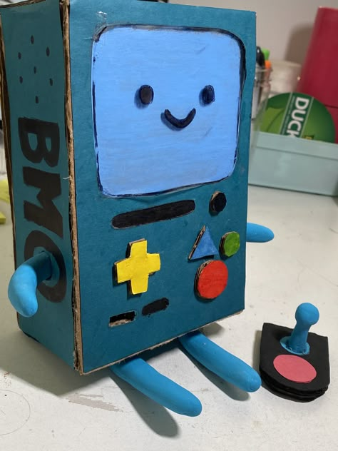 Bmo Adventure Time Clay, Adventure Time Props, Cardboard Art Easy, Adventure Time Diy Crafts, Cardboard Art Sculpture Easy, Adventure Time Decorations, Clay Bmo, Crafts Out Of Cardboard, Fin E Jake