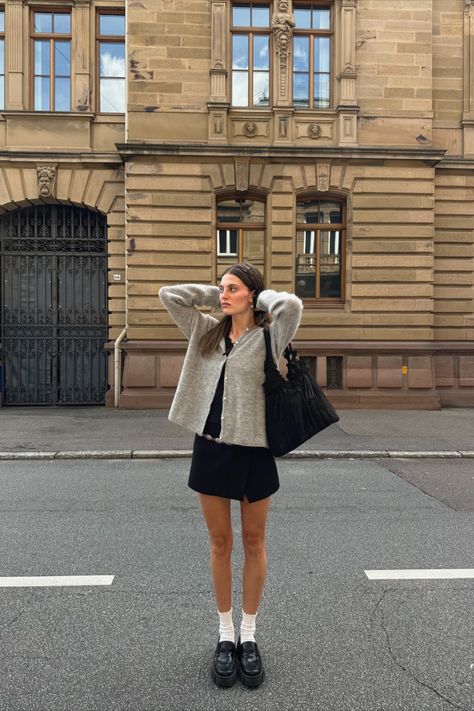 @luisa.zkr is wearing Sézane iconic Gaspard grey knit cardigan. The short black dress, white socks and black leather loafers are personal pieces. Short Grey Cardigan Outfit, Socks And Loafers Outfit, Loafers And Socks Outfits, Casual Parisian Outfits, Loafers Outfit Fall, Dress With Cardigan Outfit, Platform Loafers Outfit, Dress With Loafers, Gaspard Cardigan