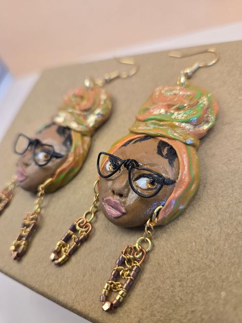 Elevate your style with the Headwrap Style N Glasses. These hand-sculpted, lightweight earrings embody the beauty of black women and their headwraps. The elegant blend of orange and green, accented with a touch of gold, exudes sophistication. These earrings also feature intricate copper details, adding a subtle sparkle to your look. Note: Earrings are made to order. My turnaround time of creating these earrings is up to 7 business days. Earring details: Lightweight Hand sculpted Made to order Width: 1 inch Length: 3.5 inches Materials: clay with copper detail, on the tiny earrings of the Elle'Centric Faces. Colors: brown, orange, green, gold, copper, pink, black, white After earrings are made, they are finished with a hand painted gloss glaze. Earring Holder Ideas, Diy Statement Earrings, Afrocentric Earrings, Afro Fashion, Head Wrap Styles, Geode Earrings, Hand Painted Earrings, African Earrings, Face Earrings