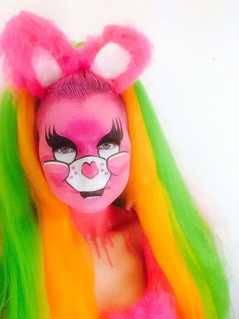 Drag queen clubkid care bear pink makeup with pink cartoon face, pink fluffy ears headpiece, pink, orange and green hair, pink drips glitter. LaceyLou Care Bear Face Paint, Care Bear Makeup, Orange And Green Hair, Care Bears Makeup, Bear Face Paint, Bear Makeup, Pink Cartoon, Cartoon Face, Face Paint Makeup