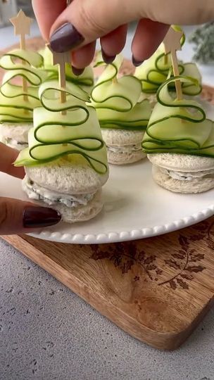 3.5K views · 7.2K reactions | Cucumber Christmas Tree Sandwiches  How adorable are these cucumber ribbon trees?! Such a fun and festive twist on a classic sandwich  You'll need  Around 1/2 cup cream cheese  1 tbsp chopped dill  1 tbsp chopped chives  1-2 tbsp lemon juice Salt and pepper to taste White bread slices  English cucumber  1- Mix all the ingredients to make the cream cheese filling.  2- Using a round cookie cutter, cut out circle bread slices.  3- Pipe the cream cheese filling onto one round bread slice and close it with another to make a sandwich.  4- To make the Christmas tree ribbons: cut out thin cucumber slices using a vegetable peeler, then fold it in a tree shape (as shown in the reel) and secure with a toothpick.  5- Add the cucumber tree ribbons onto the sandwiches and e Christmas Tree Sandwiches, Cucumber Christmas Tree, Cucumber Tree, Toothpick Appetizers, Make A Sandwich, Round Bread, Cucumber Slices, Ribbon Tree, Classic Sandwich